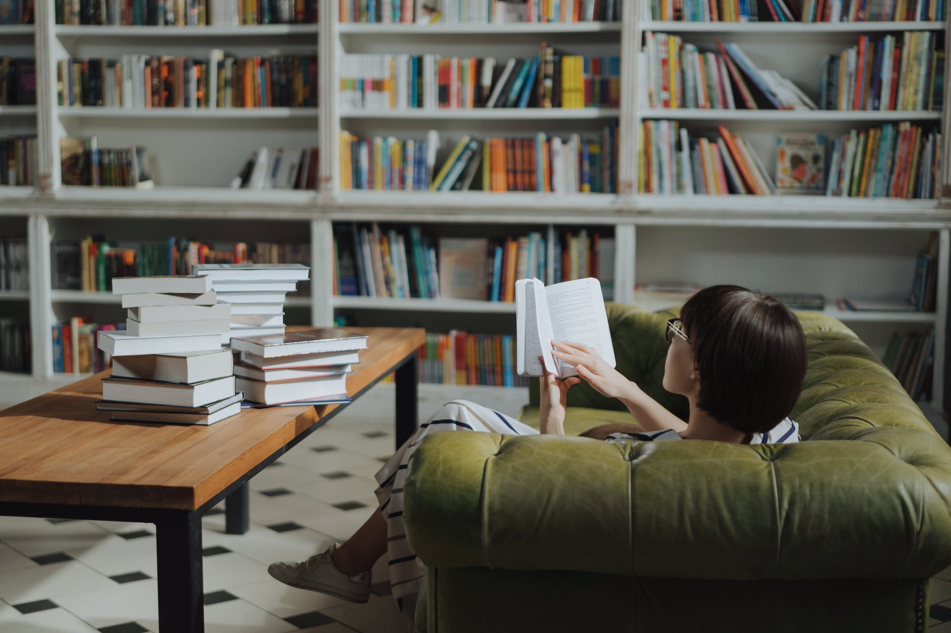 girl reading book on brown wooden table